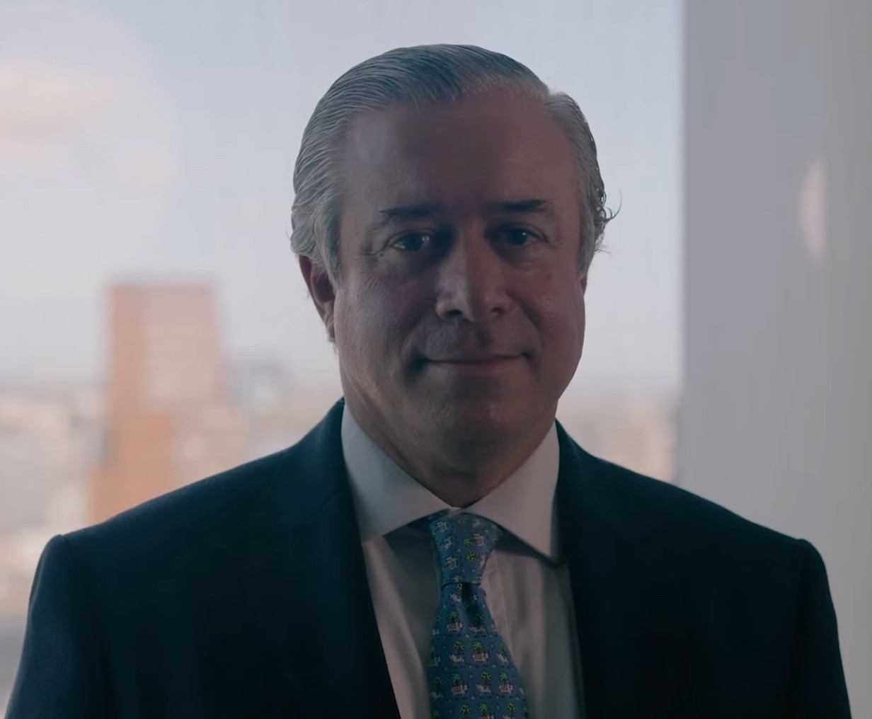 A man in a suit with a cityscape background. A man in a suit with a cityscape background.